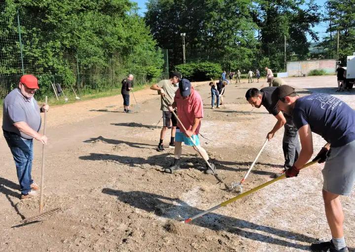 Suite à l'appel de la municipalité plus d'une vingtaine de bénévoles désherbe le terrain en sable du Chambon